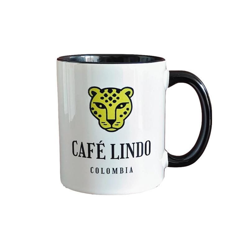 Taza oficial de Café Lindo, diseño blanco con interior negro y logo en amarillo y negro, ideal para degustar café de especialidad.