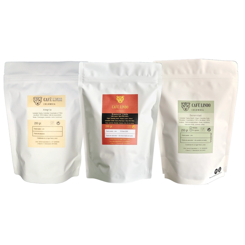 Pack de café de especialidad Café Lindo con tres bolsas de 250 g: Alegría Gesha La Palma, Esencia Lindo blend y Serenidad descafeinado, dispuestas de izquierda a derecha.
